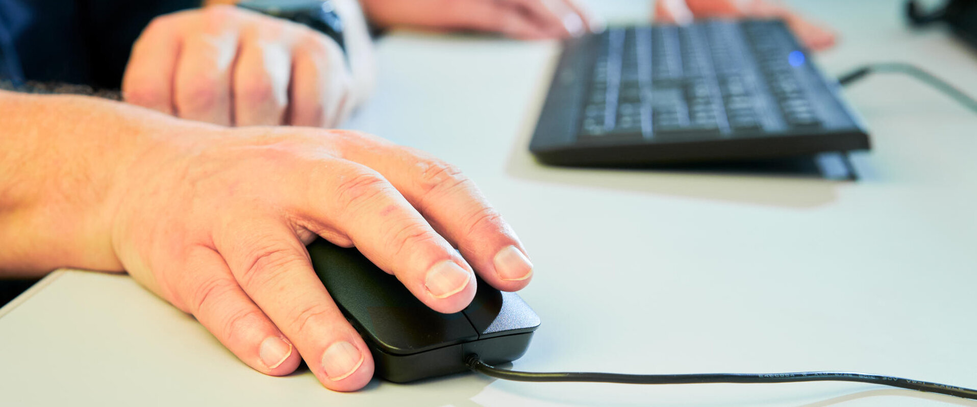 Employee with hand on computer mouse